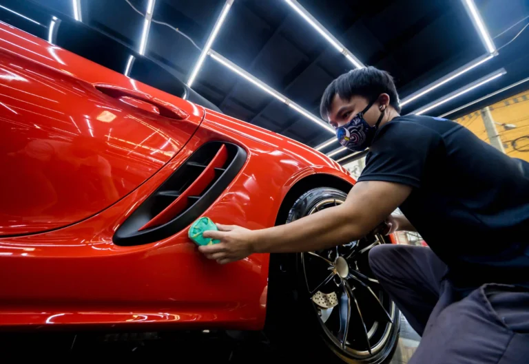 Car care professional installing a quartz plus ceramic coating in detailing center