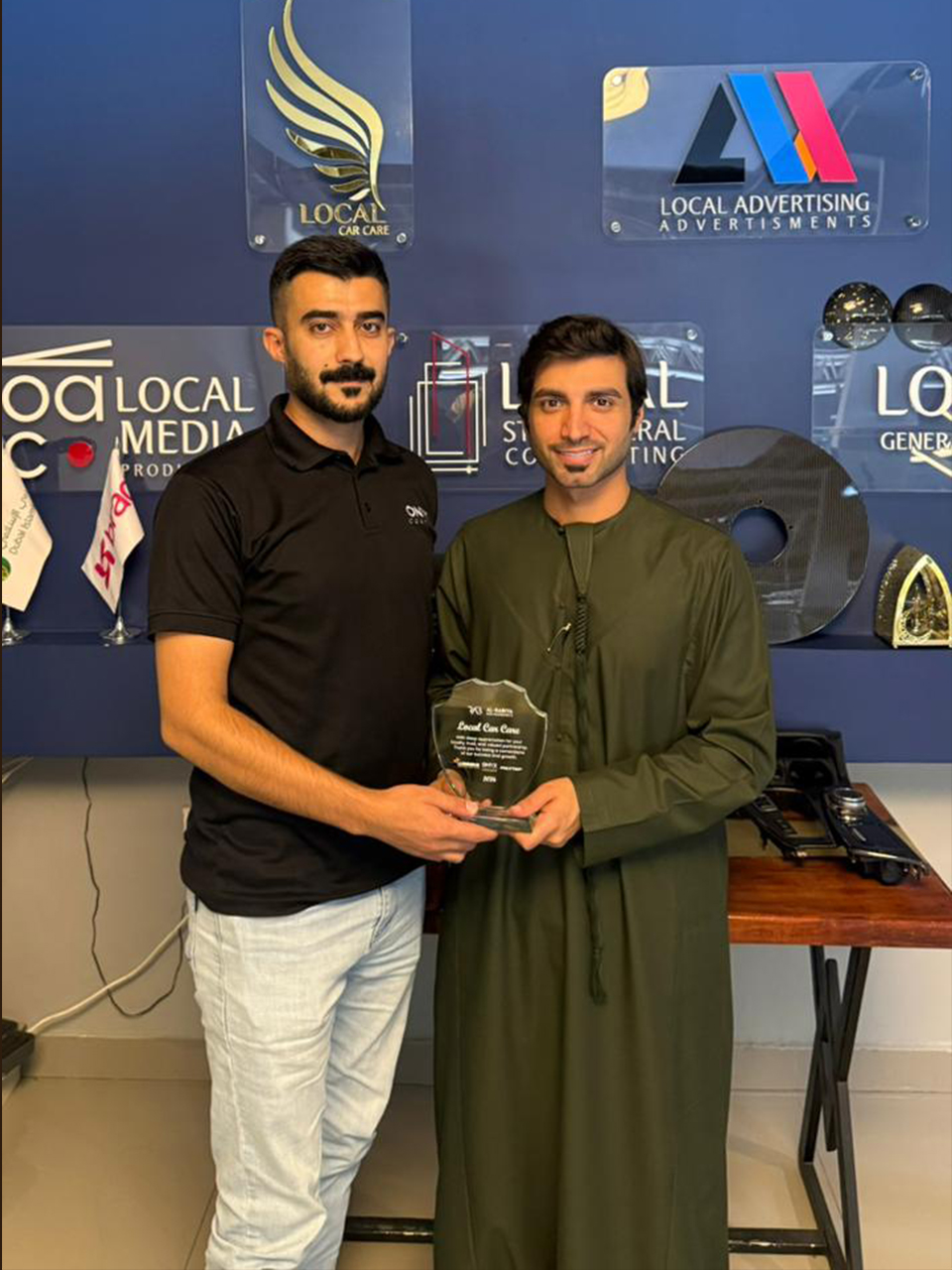 Al‑Rabiya sales representative presenting a reward to a car care partner for outstanding performance