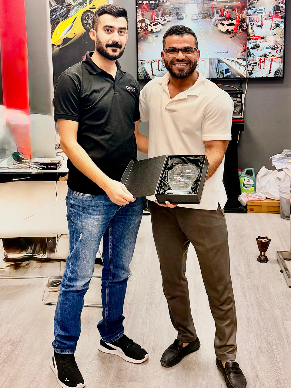 Al‑Rabiya sales representative presenting a reward to a car care partner for outstanding performance