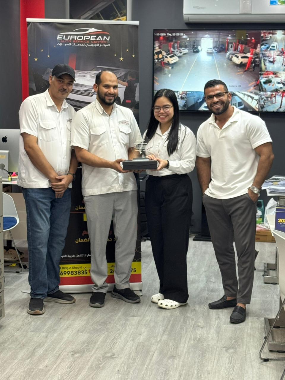Al‑Rabiya sales representative presenting a reward to a car care partner for outstanding performance