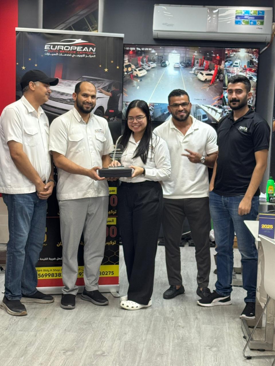 Al‑Rabiya sales representative presenting a reward to a car care partner for outstanding performance