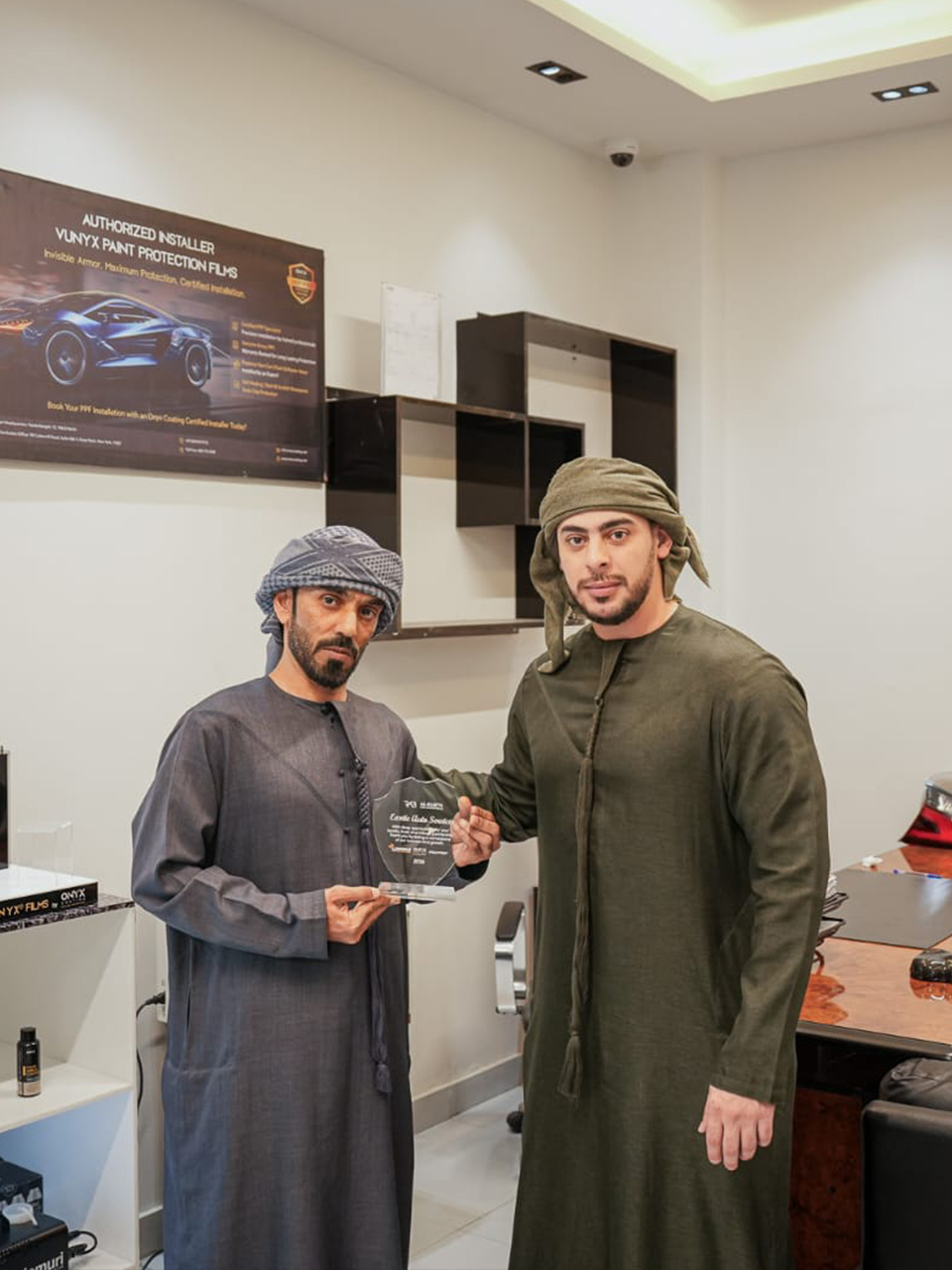 Al‑Rabiya sales representative presenting a reward to a car care partner for outstanding performance