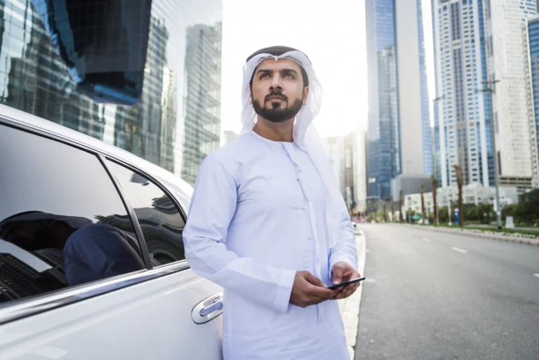 businessman-using-mobile-phone-while-standing-by-car-road-city-Al-Rabiya winter car care offer for professionals