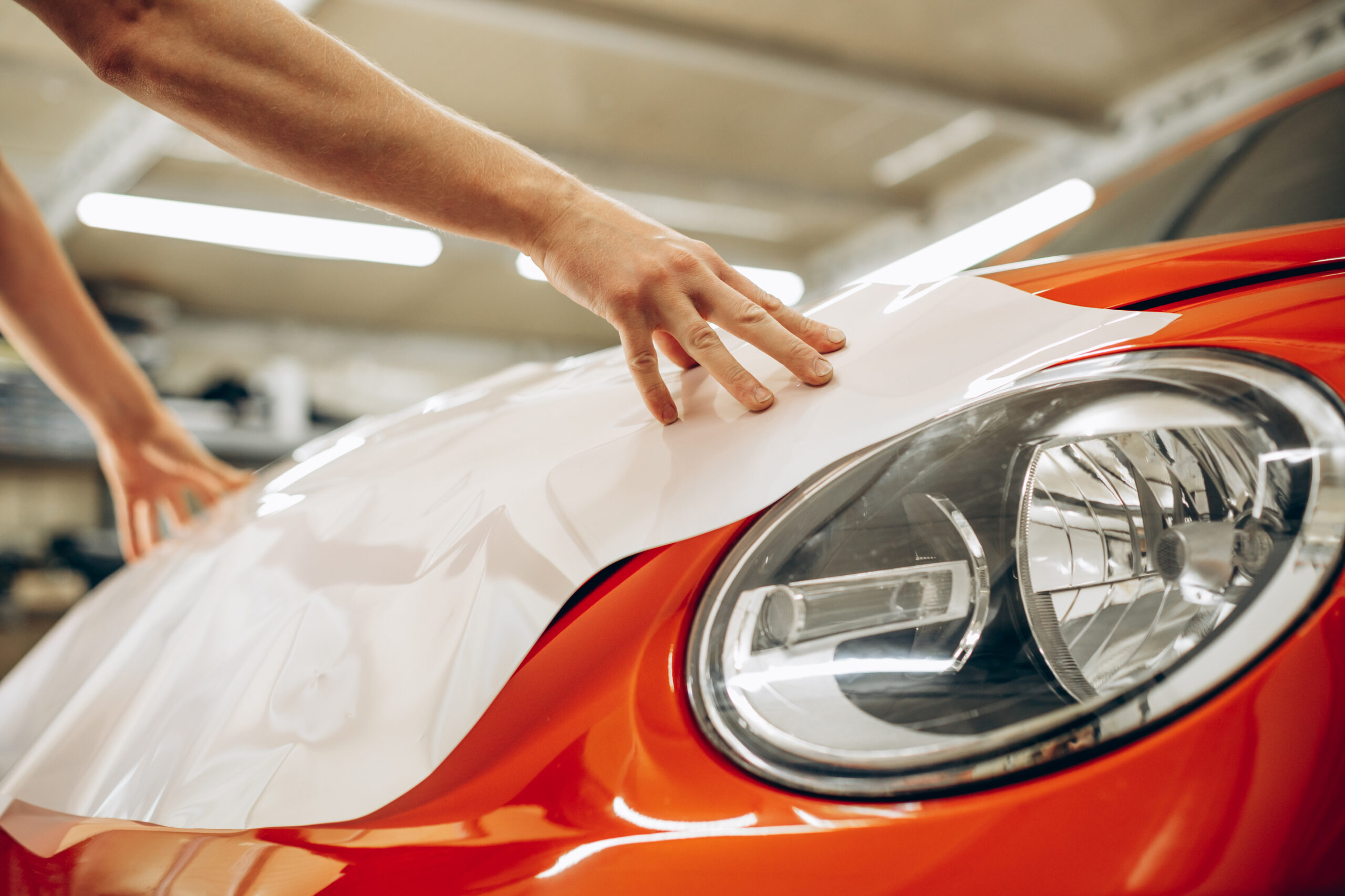 demonstrating Paint Protection Film (PPF) or ceramic coating application on a luxury vehicle