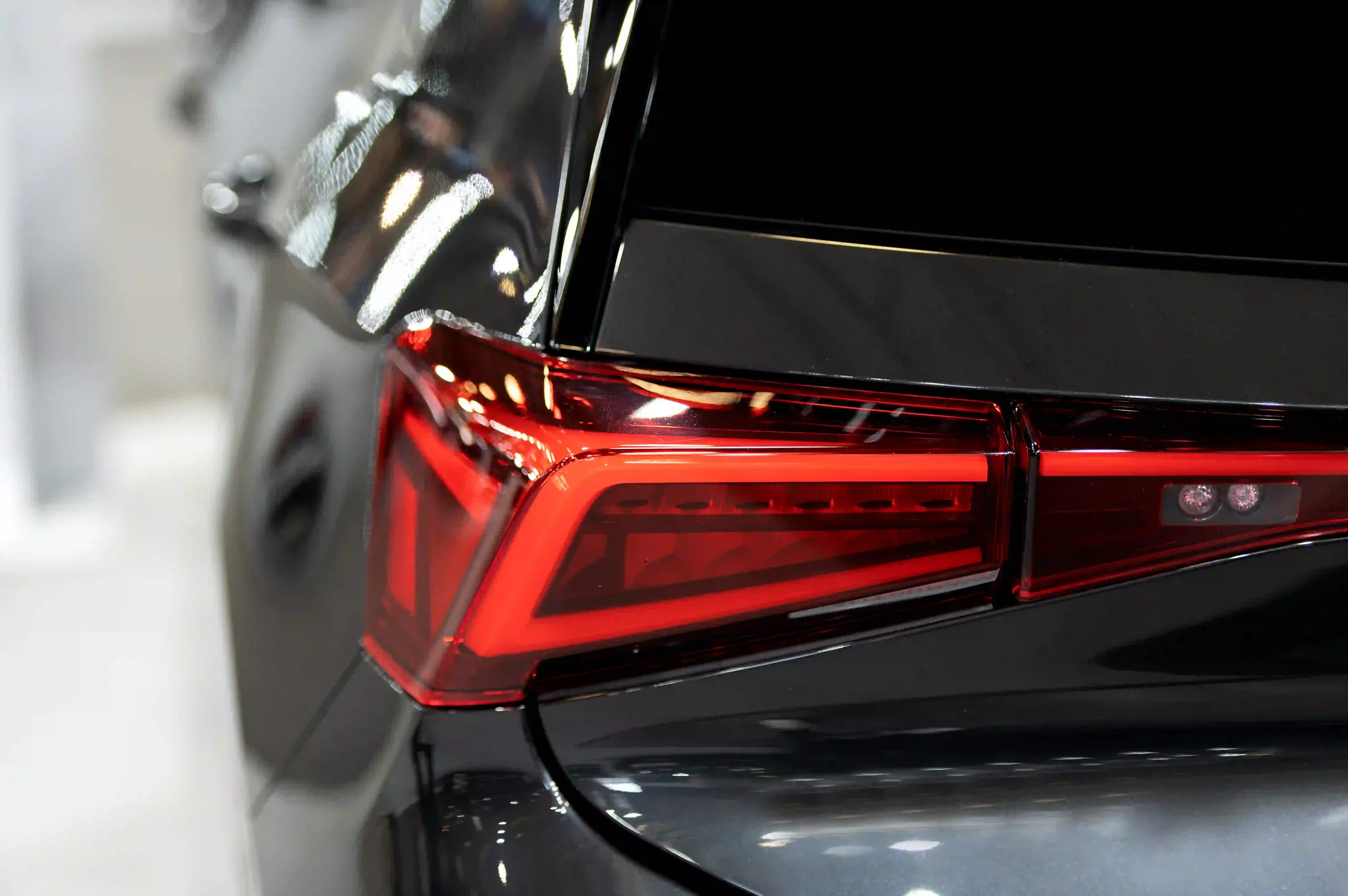 luxury car tail light dark brurred background with al-rabiya's car care products for care care centers, car dealers, body shops, car owners and mobile car wash